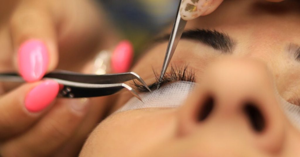 Close up of a lash technician applying eyelash extensions at a beauty salon