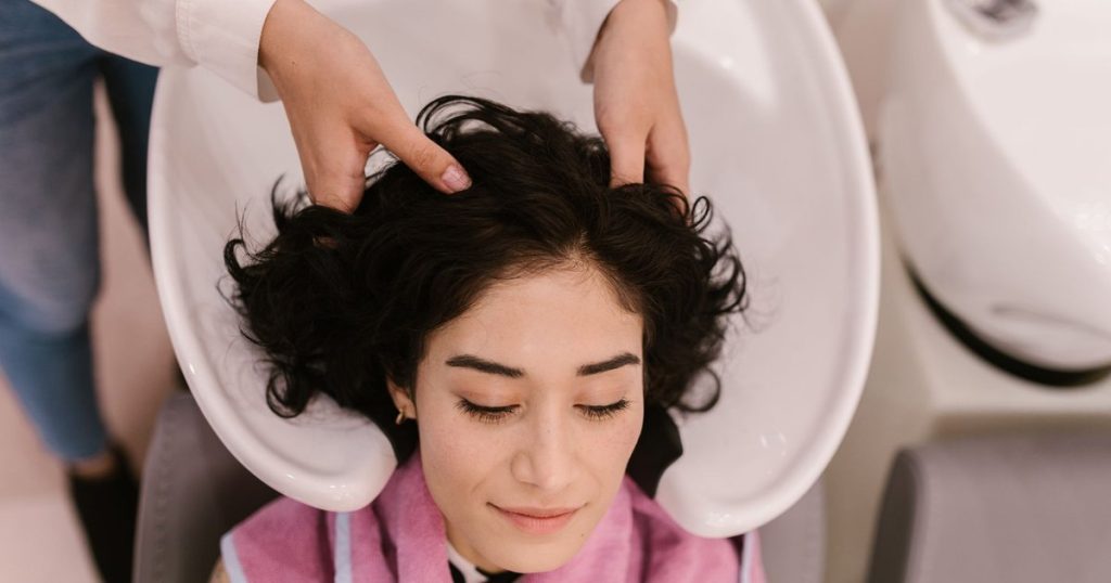 Woman having a hair repair treatment at a salon wash basin in Dubai
