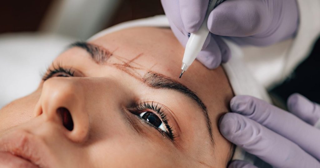 Beautician performing precise brow microblading at a waxing salon in JBR